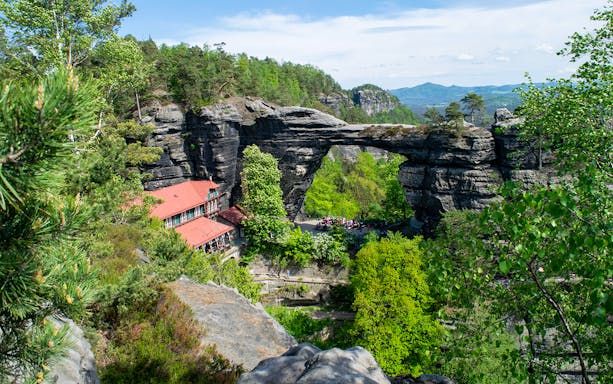 Pravčická Brána rock arch surrounded by lush greenery in Bohemian Switzerland.