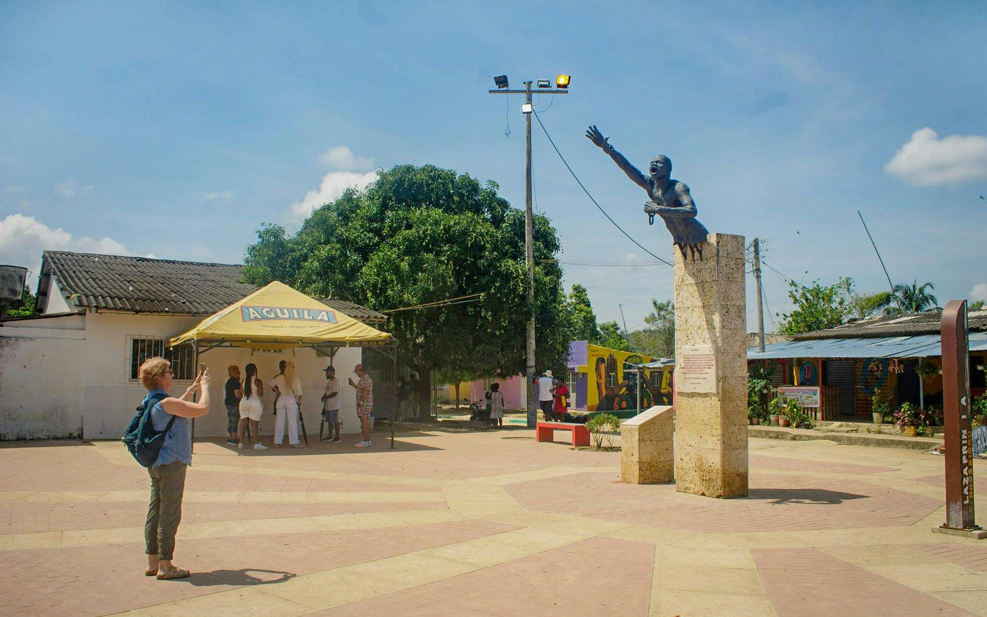 Central square with a monument in San Basilio de Palenque, people gathering nearby.