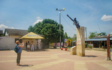 Central square with a monument in San Basilio de Palenque, people gathering nearby.