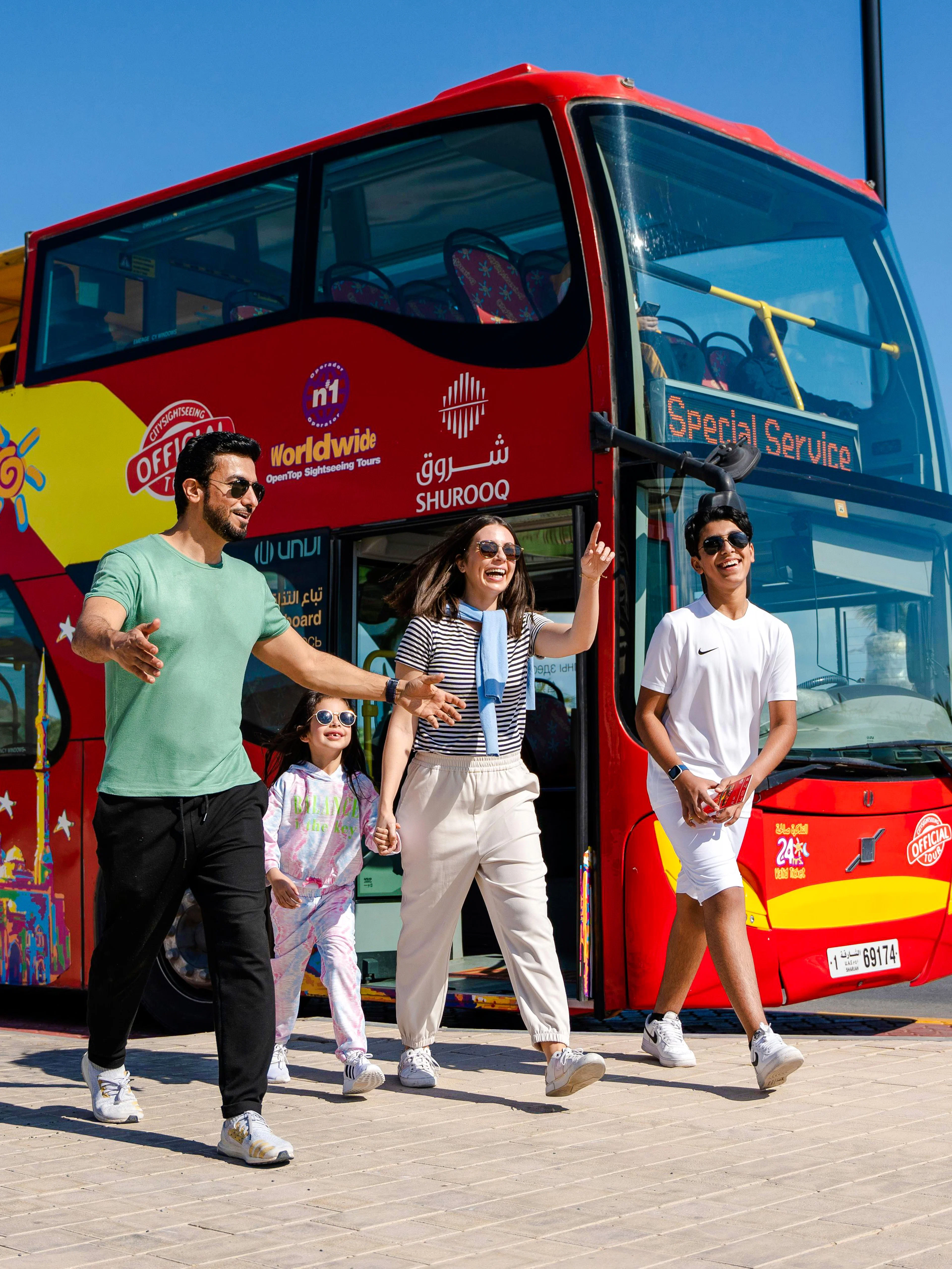 Family exiting HOHO City Sightseeing Bus in Sharjah, enjoying a sunny day tour.