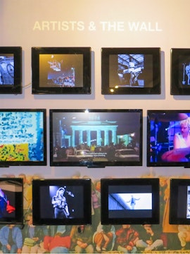 Berlin Wall Museum exhibit featuring art and historical photos.