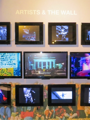 Berlin Wall Museum exhibit featuring art and historical photos.