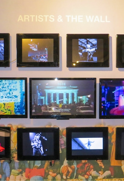 Berlin Wall Museum exhibit featuring art and historical photos.