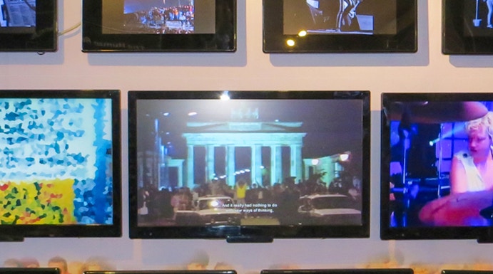 Berlin Wall Museum exhibit featuring art and historical photos.