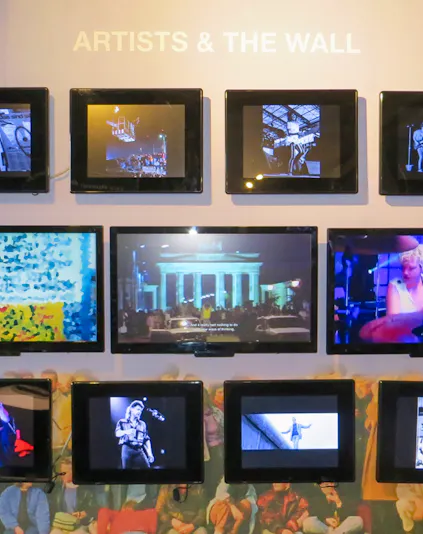 Berlin Wall Museum exhibit featuring art and historical photos.