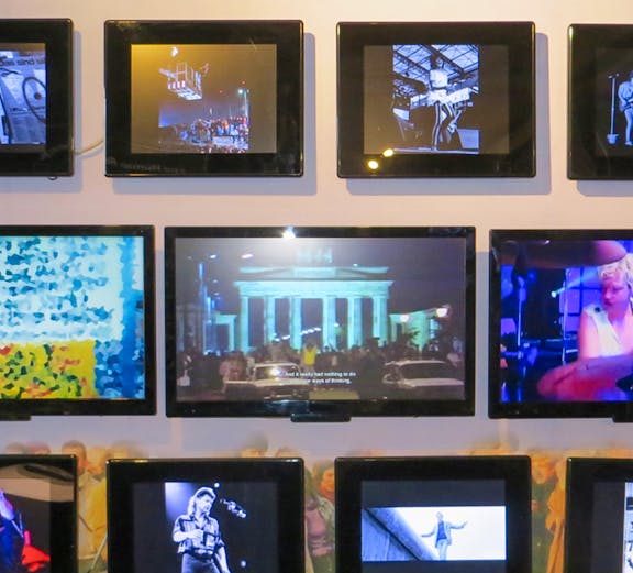 Berlin Wall Museum exhibit featuring art and historical photos.