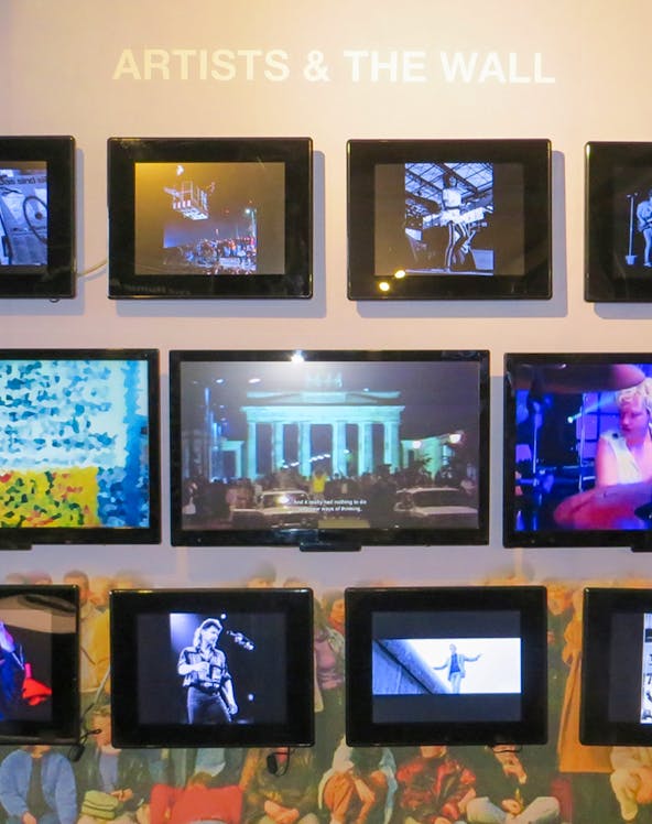 Berlin Wall Museum exhibit featuring art and historical photos.