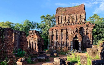 Ancient brick temple ruins at My Son Sanctuary, surrounded by greenery, Hoi An.