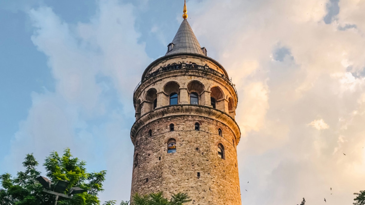 Galata Tower overlooking Bosphorus with cruise ship in Istanbul, Turkey.