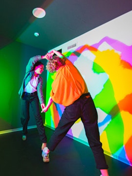 Visitors interacting with colorful light shadows at Paradox Museum.