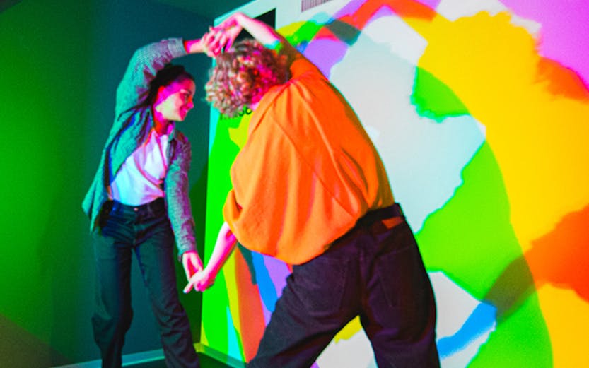 Visitors interacting with colorful light shadows at Paradox Museum.