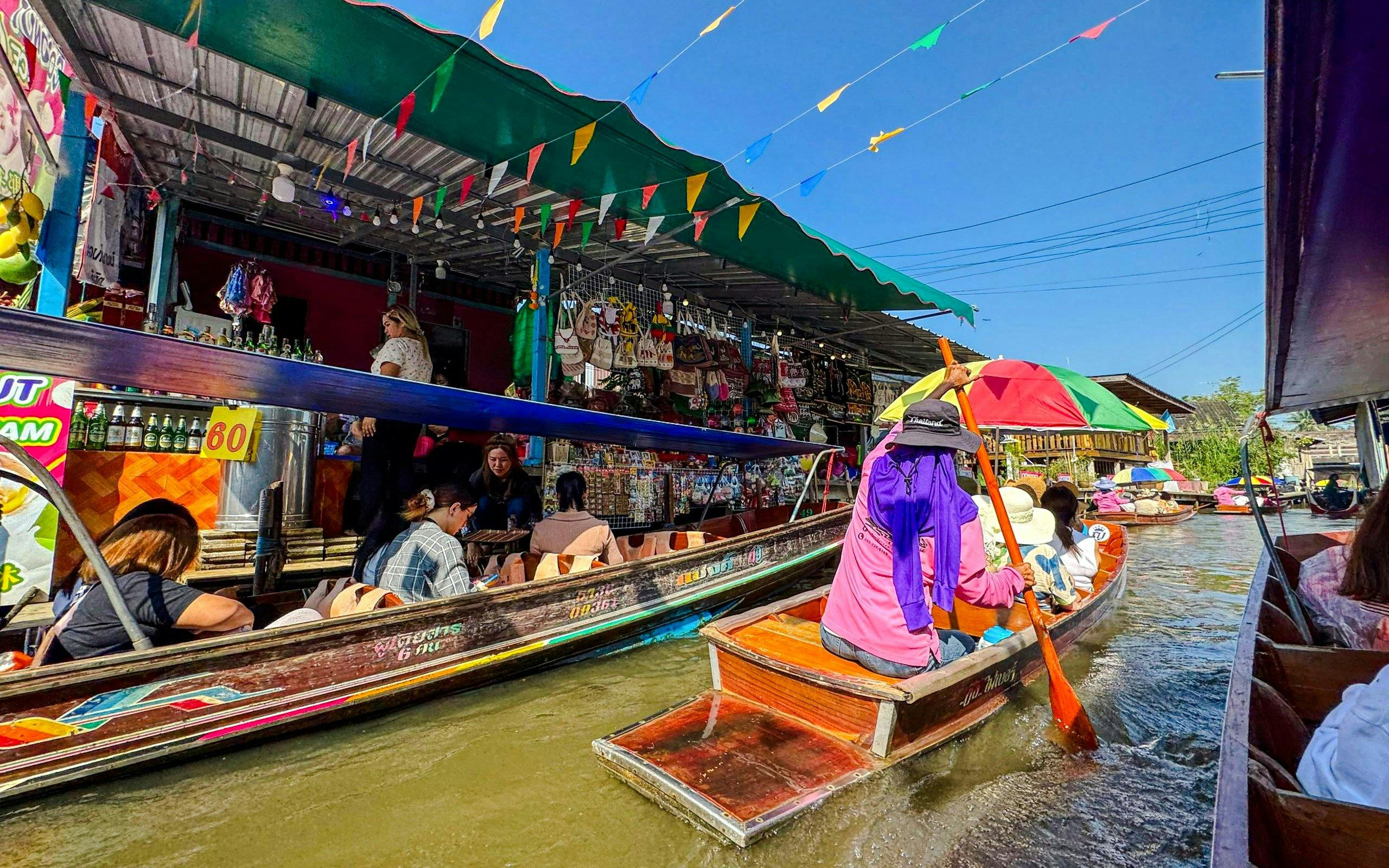 Tourists on boats navigating Damnoen Saduak Floating Market, Thailand.