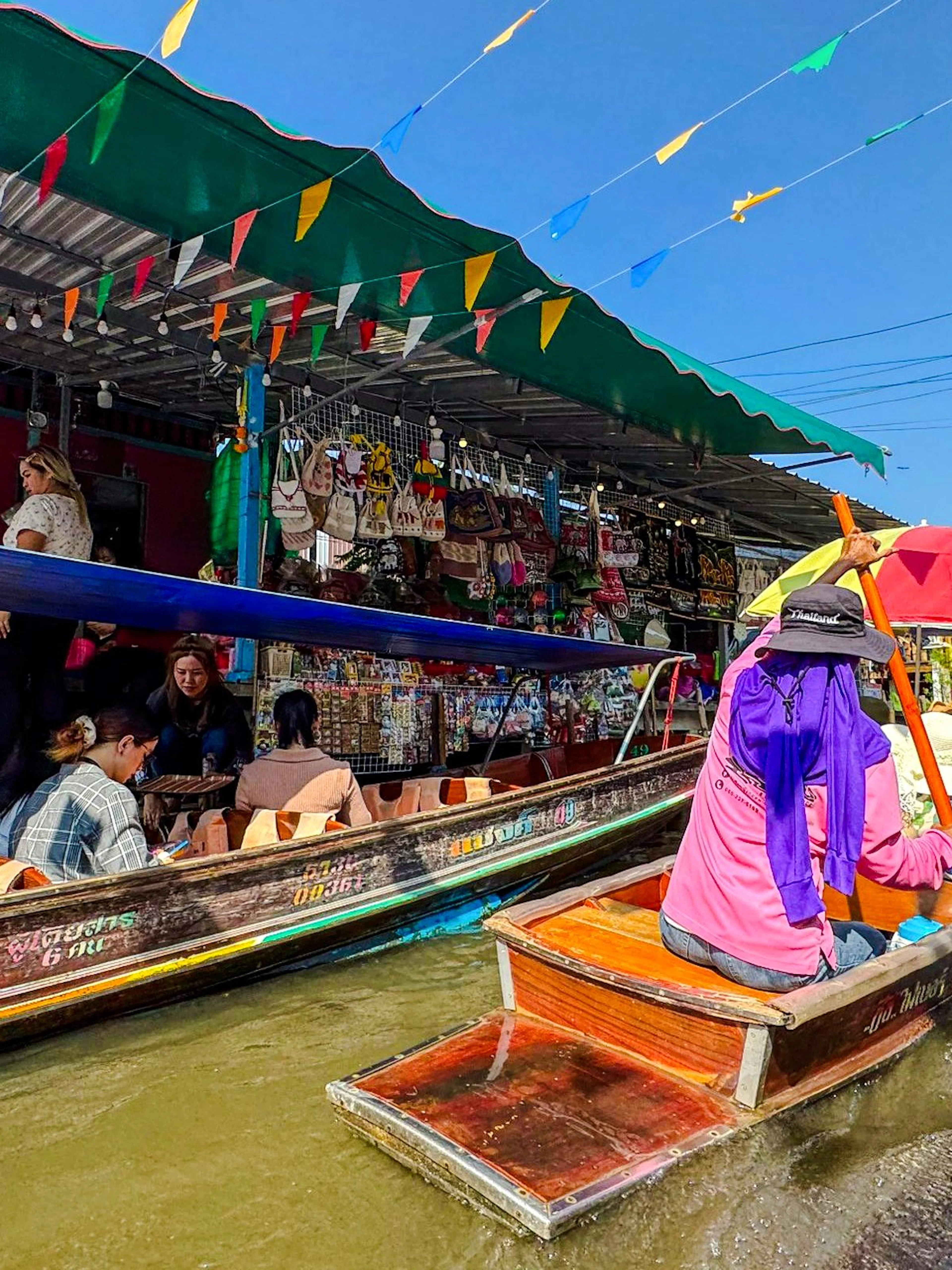 Tourists on boats navigating Damnoen Saduak Floating Market, Thailand.