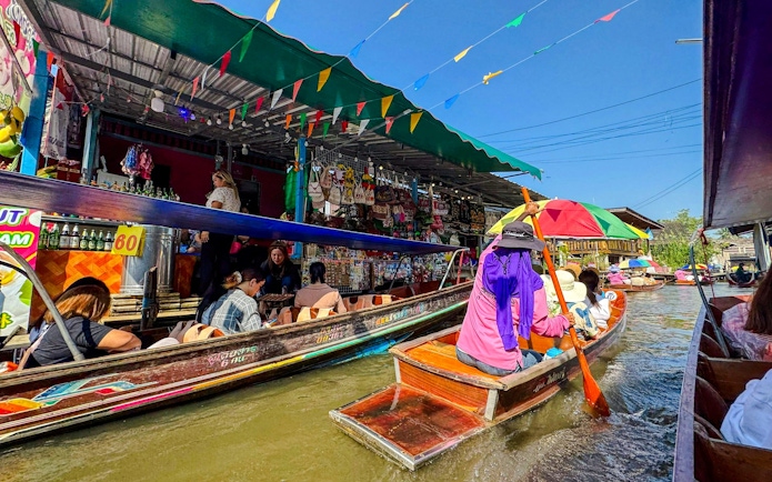 Tourists on boats navigating Damnoen Saduak Floating Market, Thailand.