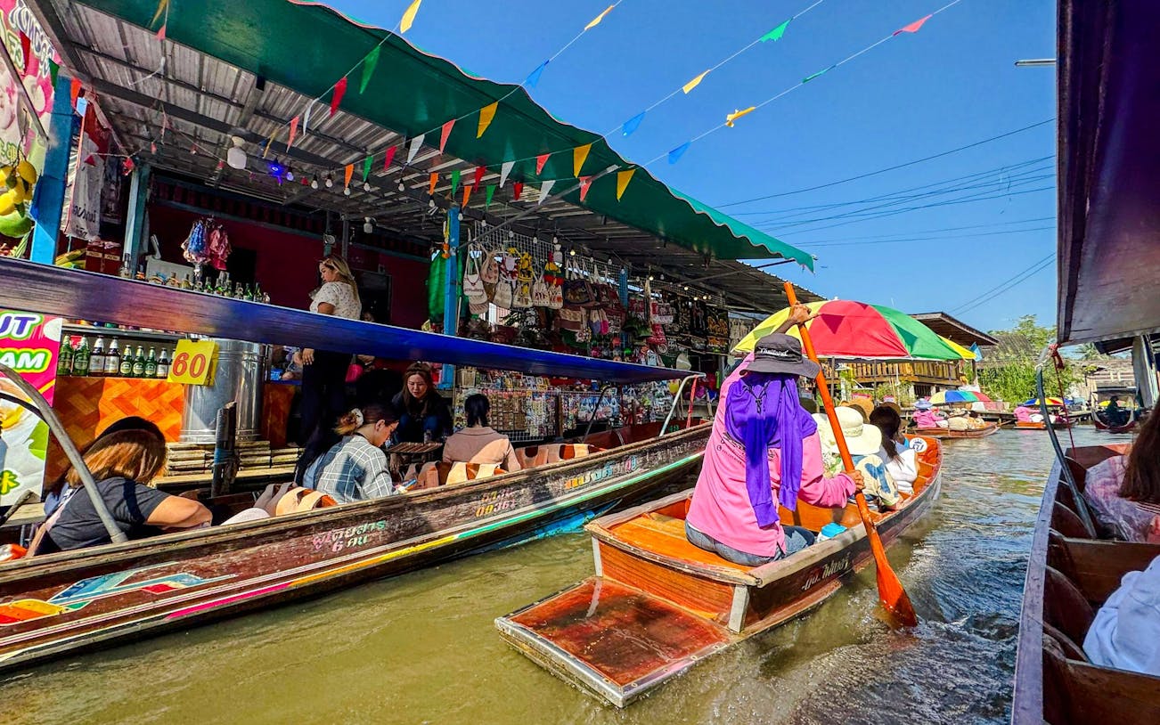 Tourists on boats navigating Damnoen Saduak Floating Market, Thailand.