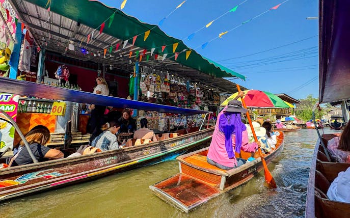 Tourists on boats navigating Damnoen Saduak Floating Market, Thailand.