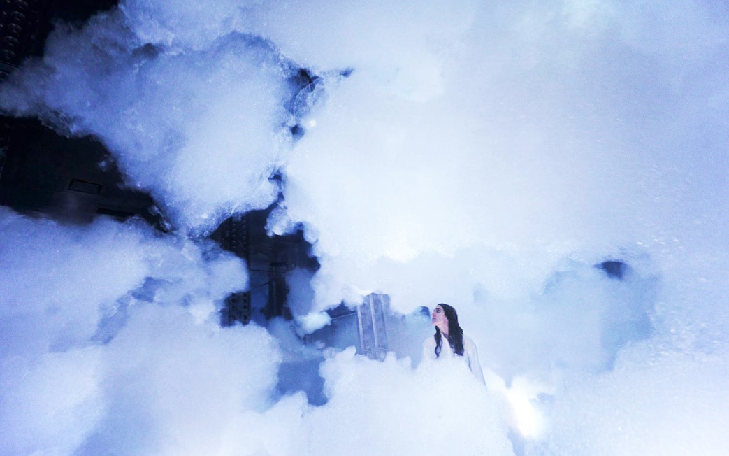 Visitor exploring immersive fog installation at teamLab SuperNature Macau.