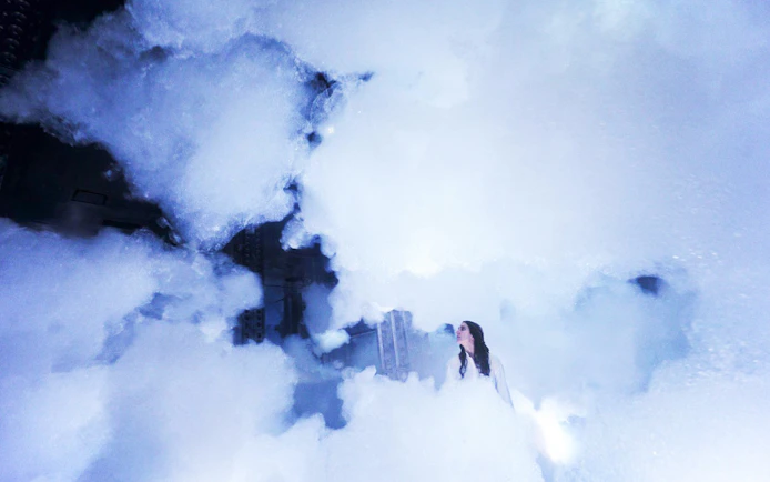 Visitor exploring immersive fog installation at teamLab SuperNature Macau.