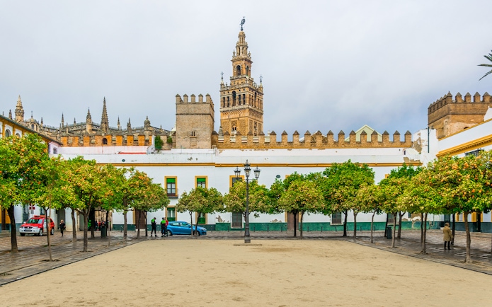 La Giralda tower with courtyard and orange trees in Seville, Spain.