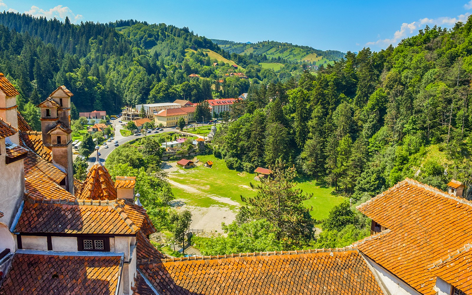 Bran Castle view of Romania cityscape with forested hills and village.