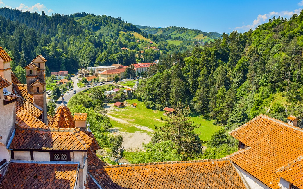 Bran Castle view of Romania cityscape with forested hills and village.