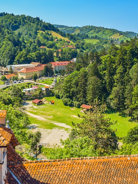 Bran Castle view of Romania cityscape with forested hills and village.