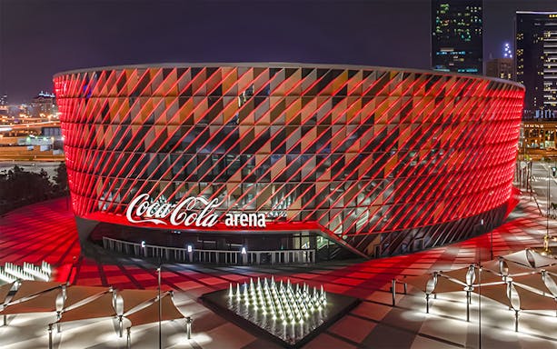 Coca-Cola Arena illuminated at night, venue for Sonu Nigam live concert in Dubai.