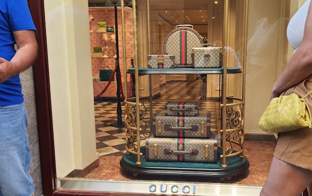 Luxury luggage display at a designer store in Rome, featuring iconic Italian fashion.
