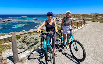 Cyclists on Rottnest Island with ocean view, accessible via ferry from Perth or Fremantle.