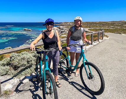 Cyclists on Rottnest Island with ocean view, accessible via ferry from Perth or Fremantle.