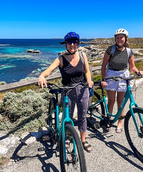 Cyclists on Rottnest Island with ocean view, accessible via ferry from Perth or Fremantle.