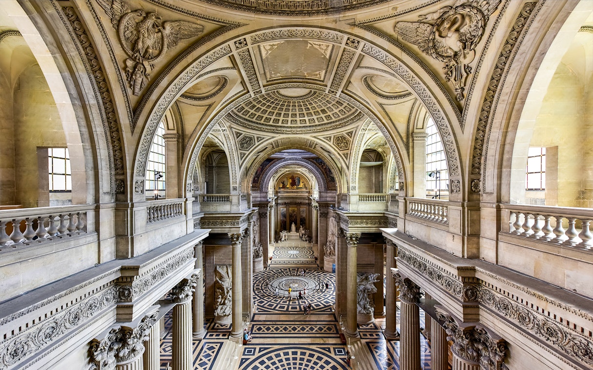Interior view of the Pantheon in Paris, showcasing ornate architecture and detailed carvings.