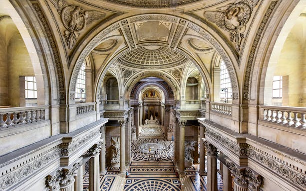 Interior view of the Pantheon in Paris, showcasing ornate architecture and detailed carvings.