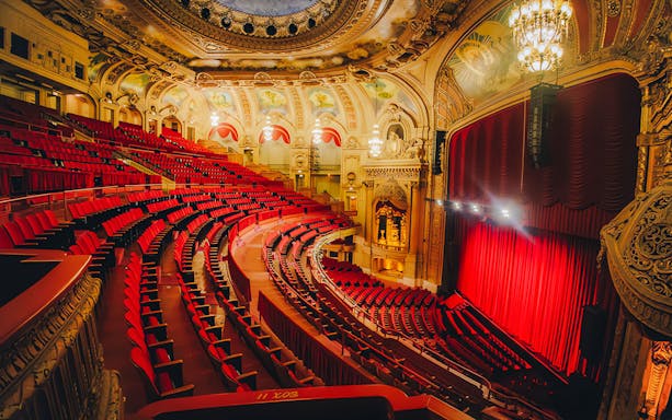Chicago Theatre interior with ornate ceiling and red seats, highlighting The Chicago Theatre Tour Experience.
