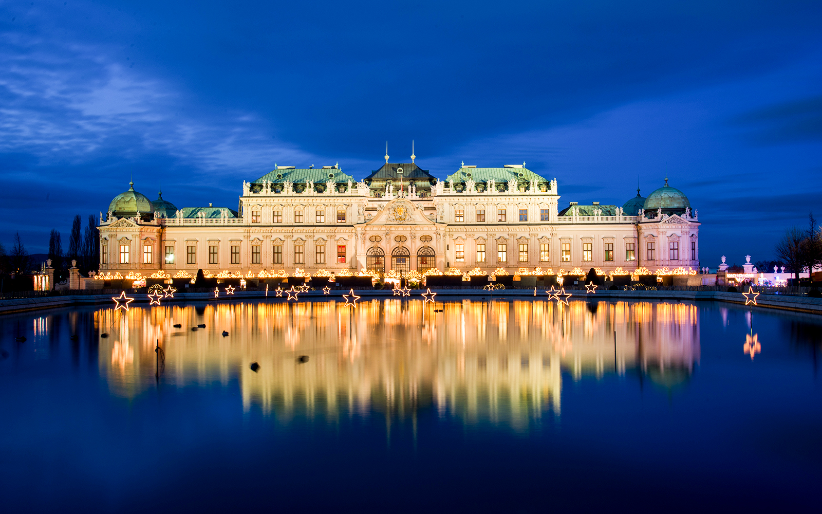 Palace Belvedere illuminated at night with reflections in the pond, Vienna, Austria.