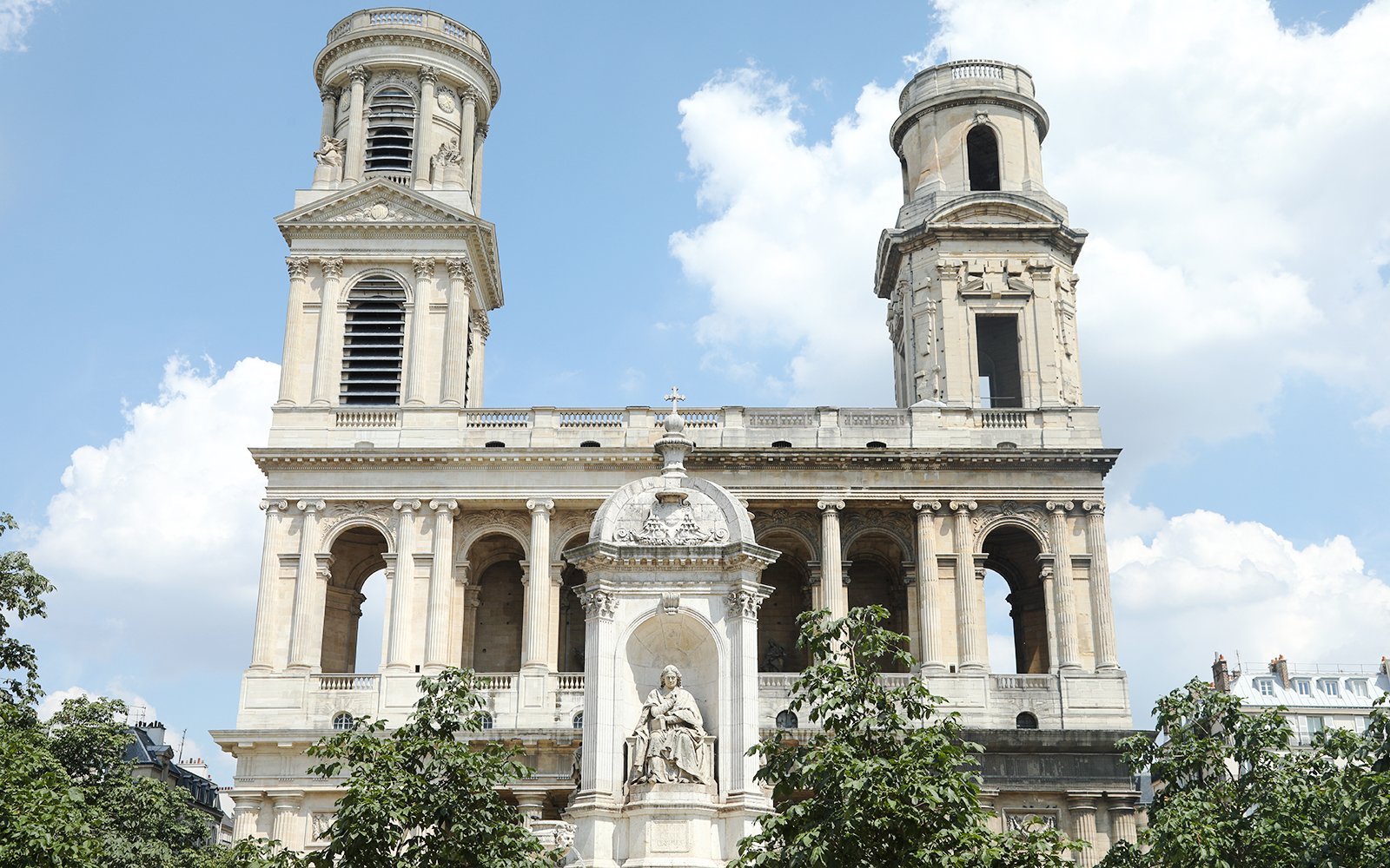 St Sulpice Church facade with twin towers and central statue in Paris.