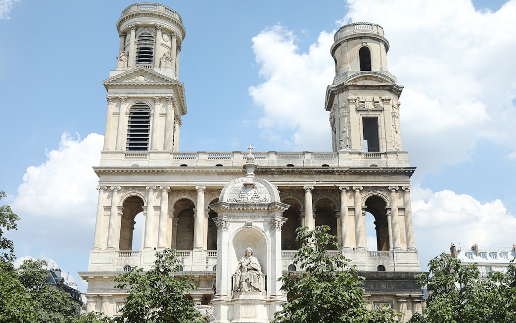 St Sulpice Church facade with twin towers and central statue in Paris.