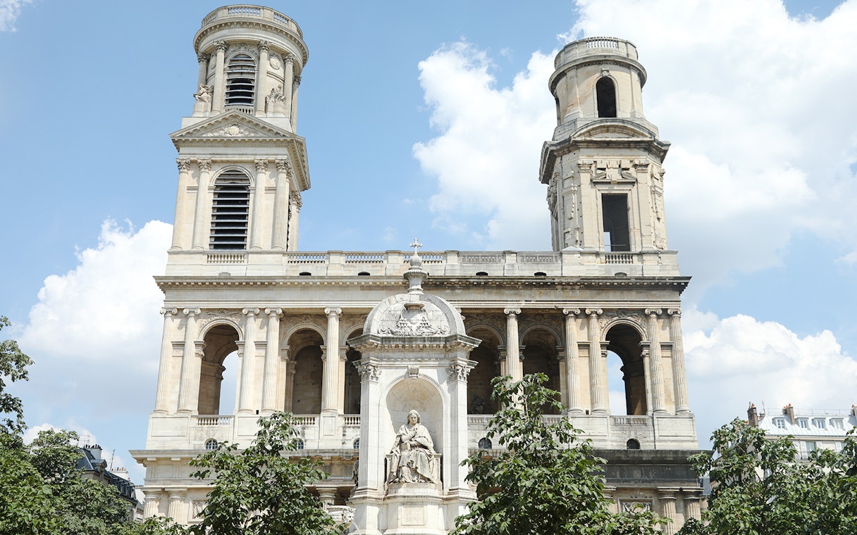 St Sulpice Church facade with twin towers and central statue in Paris.