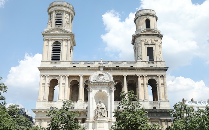 St Sulpice Church facade with twin towers and central statue in Paris.