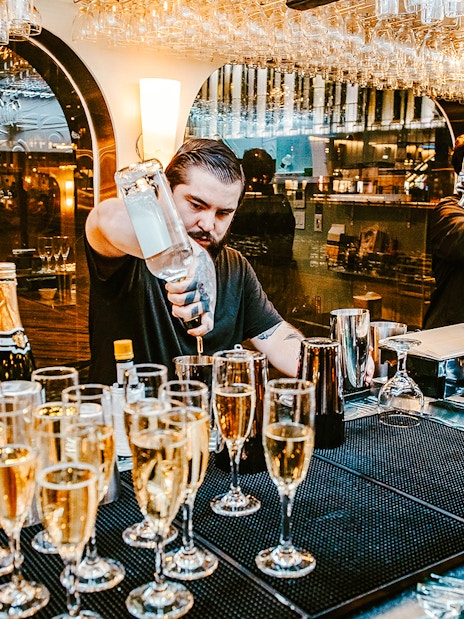 Bartender preparing drinks on New Year's Eve dinner cruise.