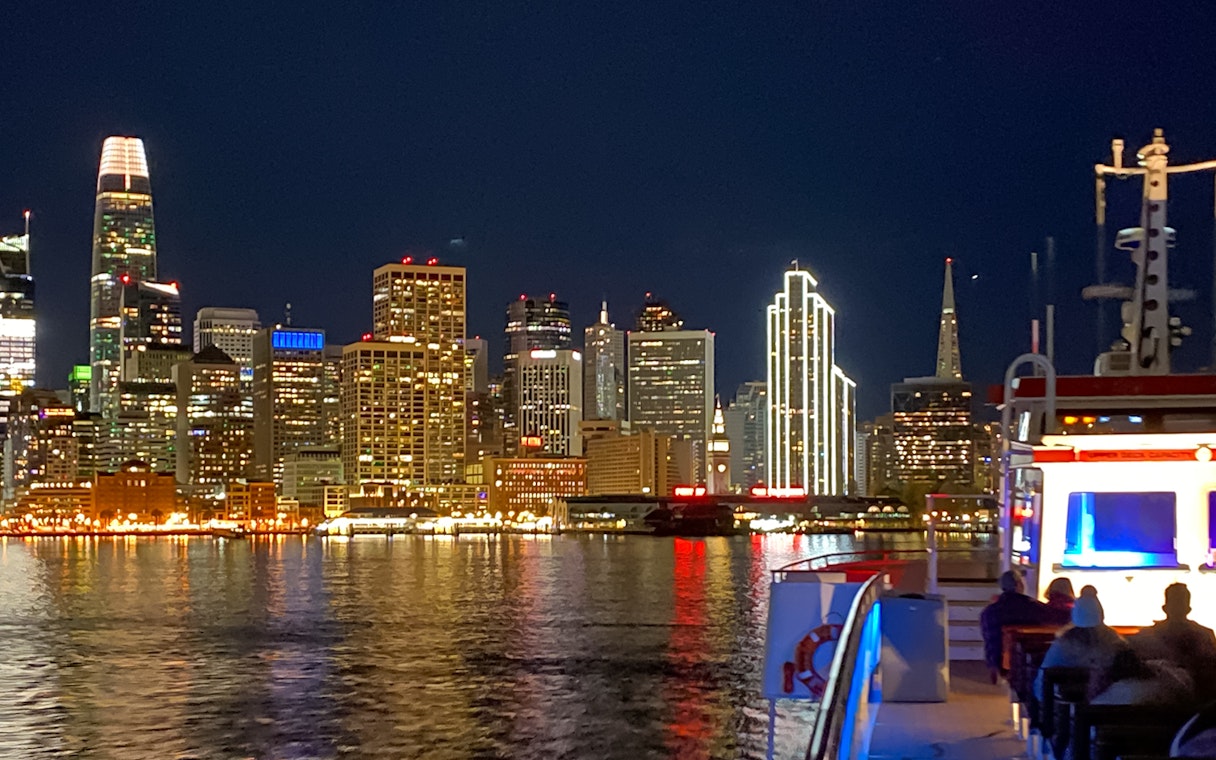 Guests on deck viewing San Francisco skyline during California Sunset cruise.