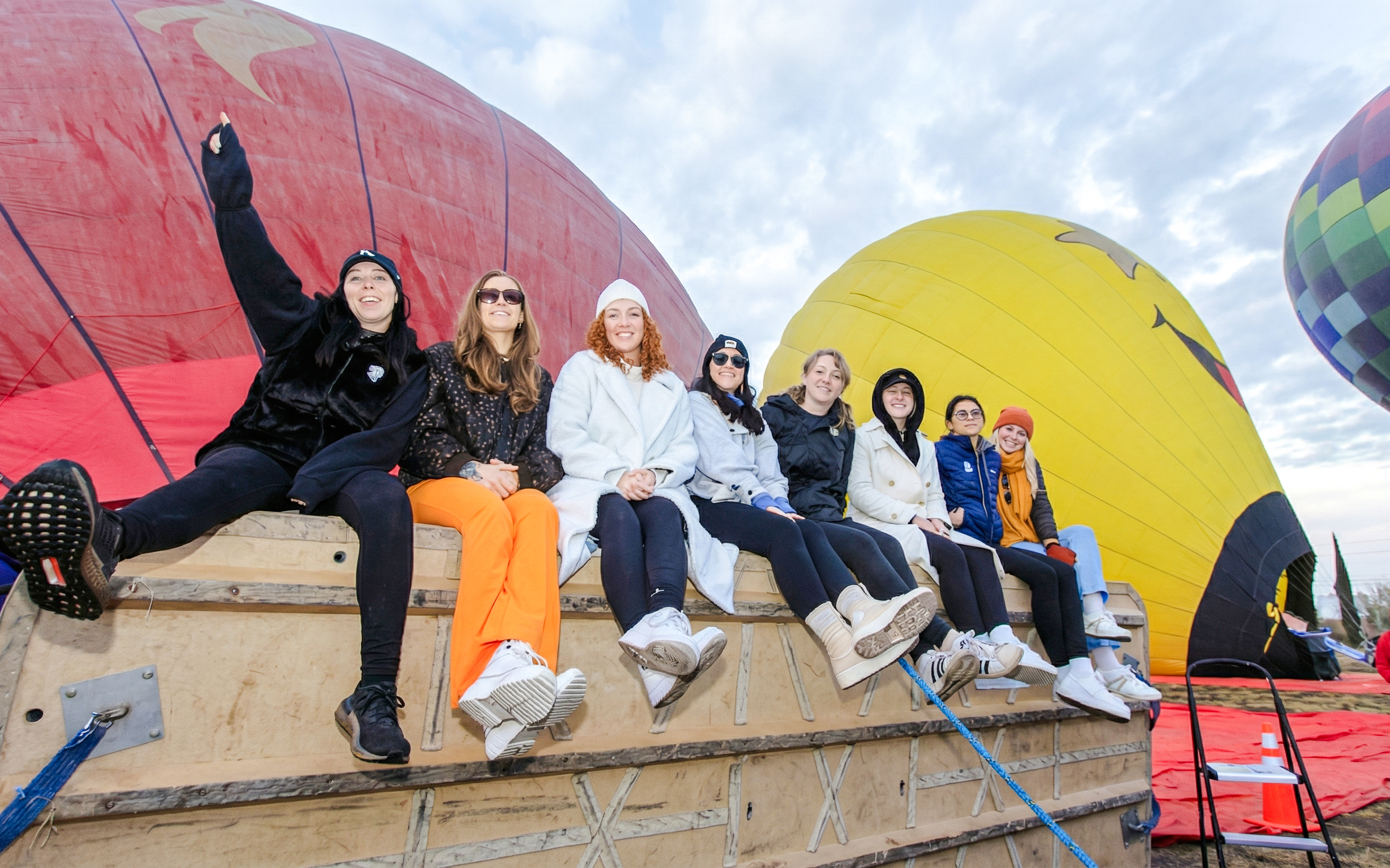 Group of people sitting on a basket with colorful hot air balloons in Mexico City.