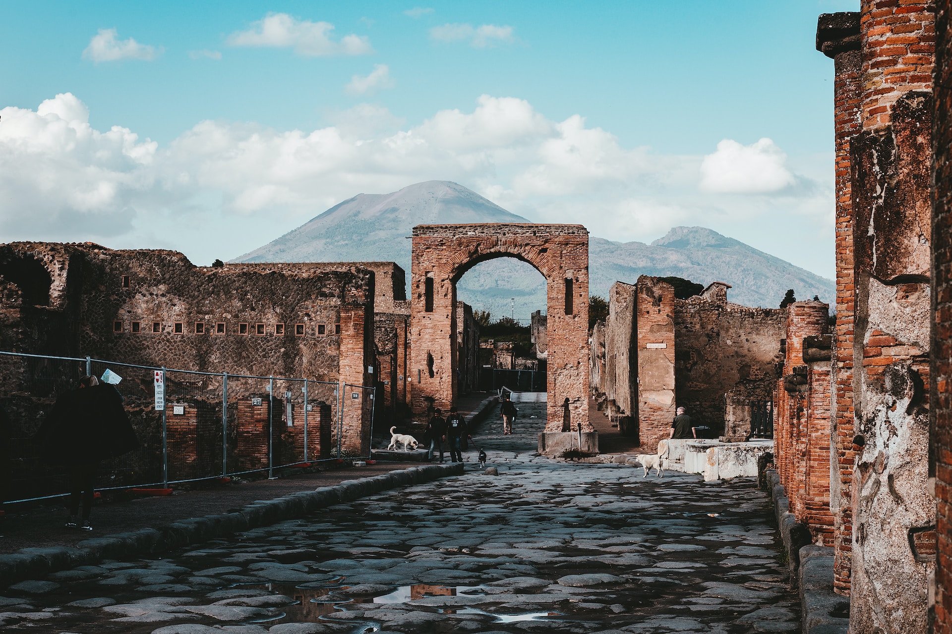Ancient ruins and archway with Mount Vesuvius in the background at Pompeii Archaeological Park.