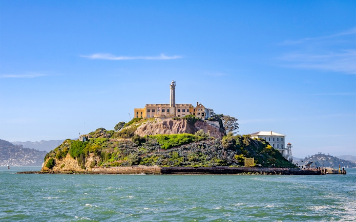 Ferry view of Alcatraz Island with historic buildings in San Francisco Bay.