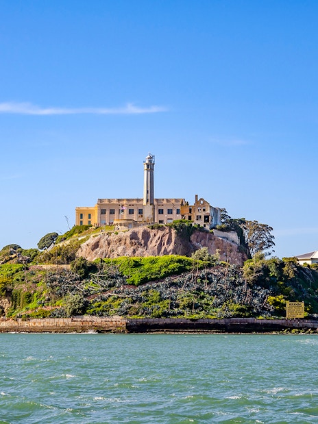 Ferry view of Alcatraz Island with historic buildings in San Francisco Bay.