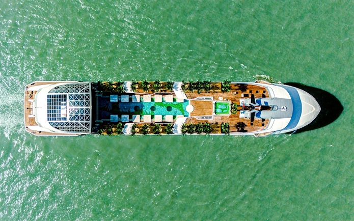 Aerial view of a cruise ship deck with pool and seating, Dolphin Cruise.