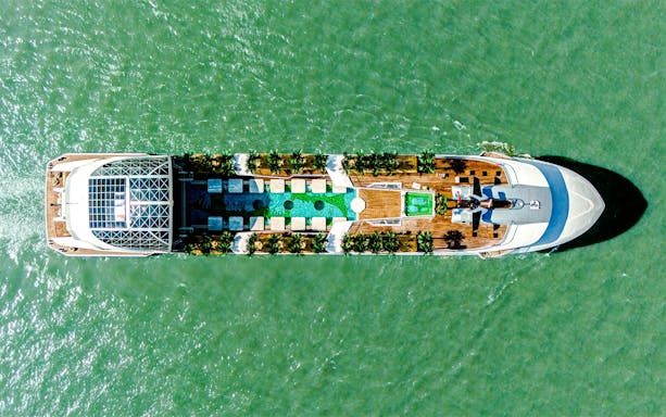 Aerial view of a cruise ship deck with pool and seating, Dolphin Cruise.