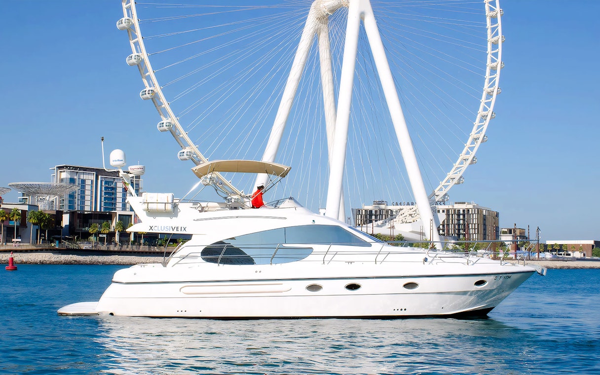 Luxury yacht cruising near Ain Dubai Ferris wheel.