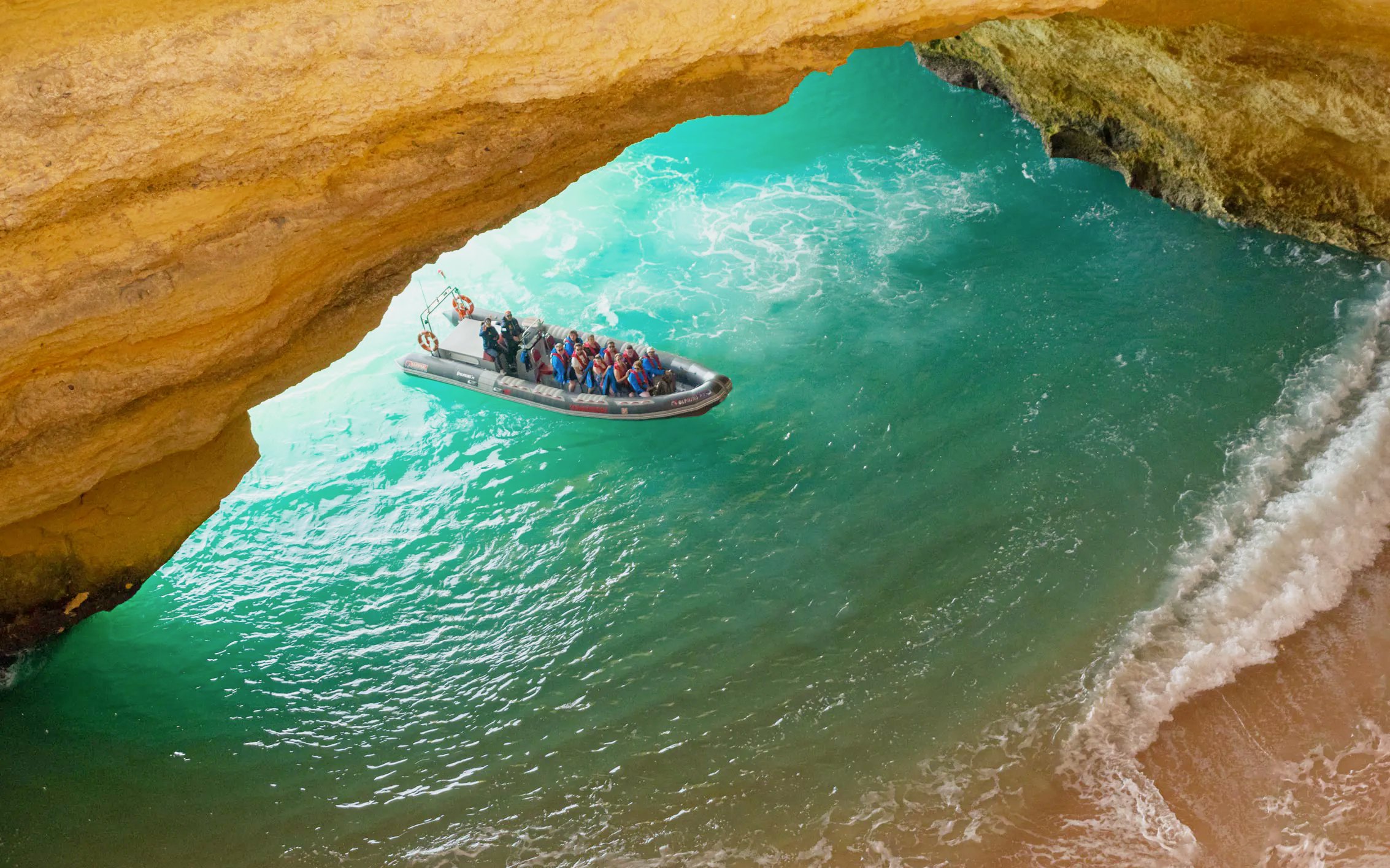 Tourists on RIB boat entering Benagil Caves, Algarve, Portugal.