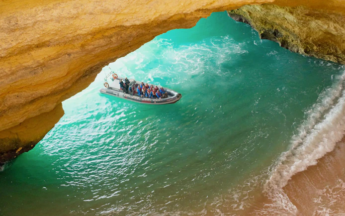Tourists on RIB boat entering Benagil Caves, Algarve, Portugal.